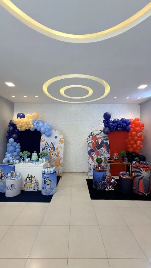 Decorações de festa infantil tema Bluey e tema Homem-Aranha, com arcos de balões, no Espaço Vila do Sol em Divinópolis